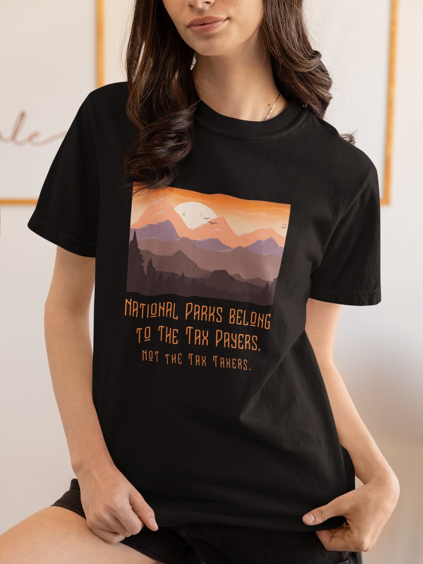 Person wearing a black t-shirt with a mountain graphic and text.