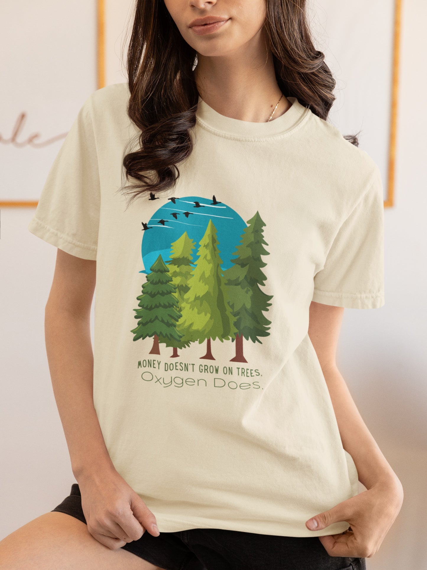 Person wearing a t-shirt with a graphic of trees and text.