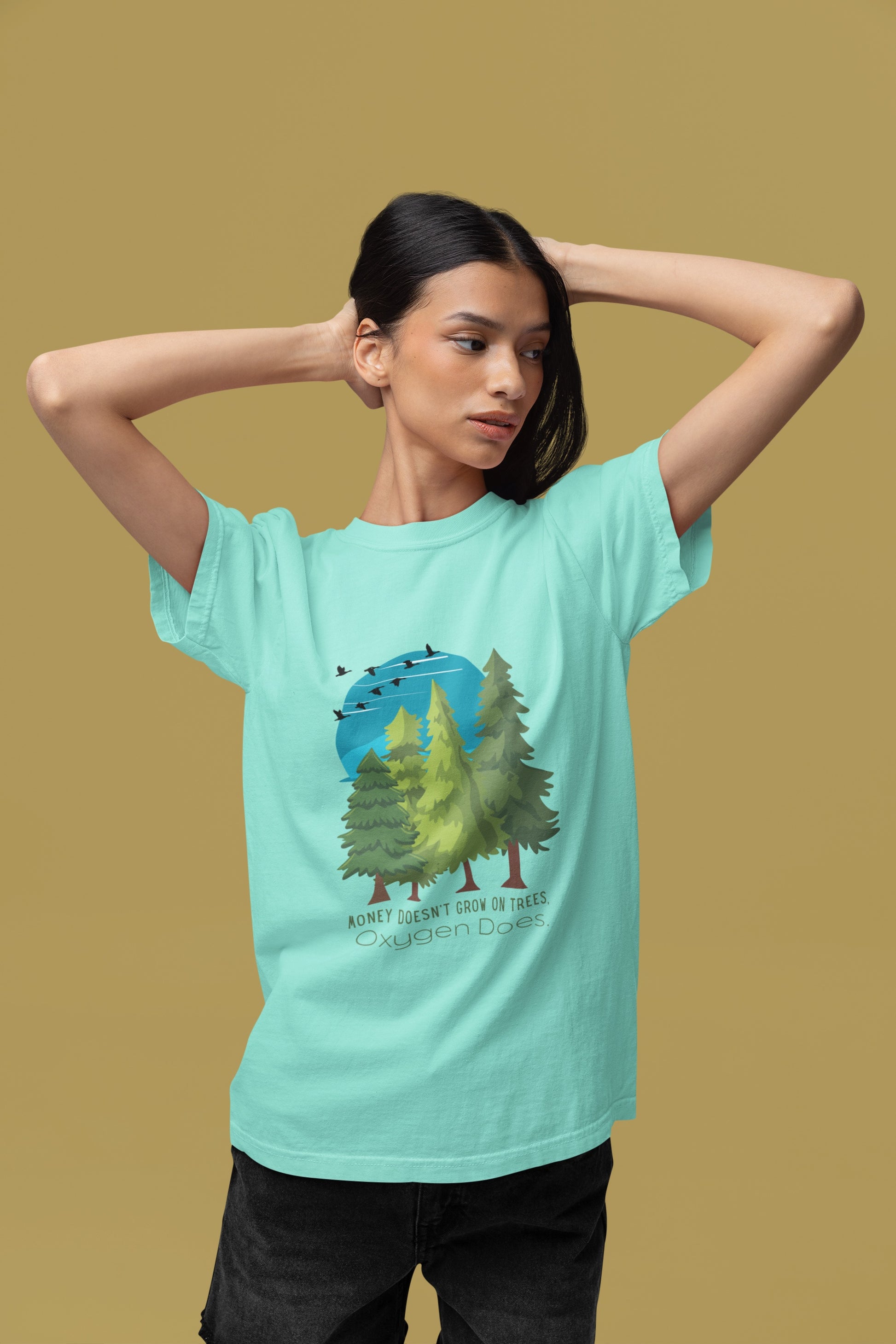 Person wearing a light blue t-shirt with a nature graphic on a beige background