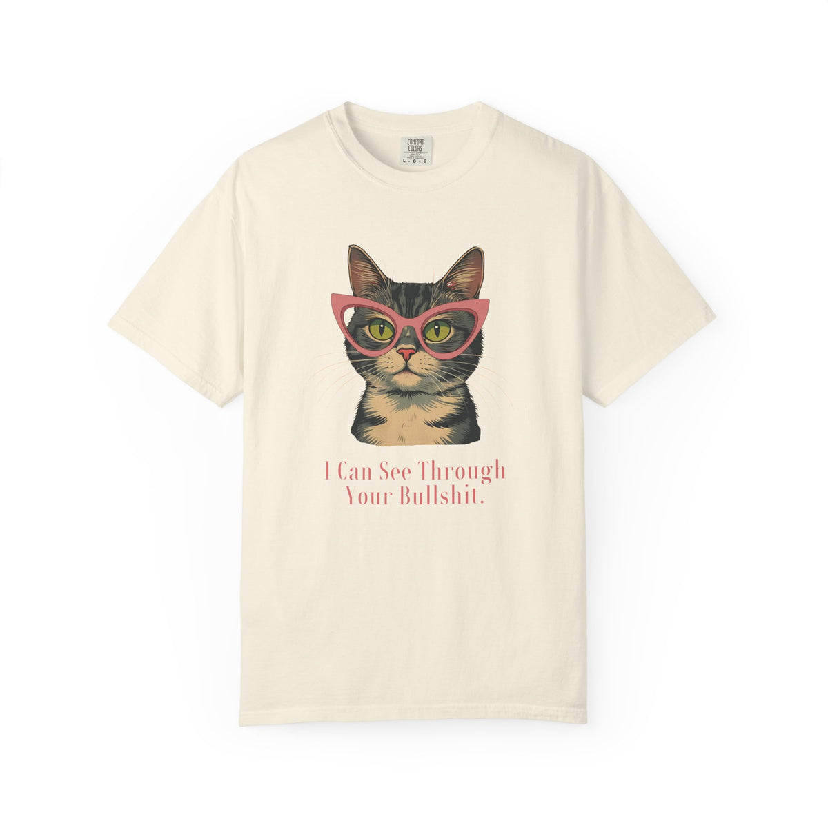An off-white short-sleeve t-shirt with a graphic of a tabby cat wearing pink glasses and the text 'I Can See Through Your Bullshit.' printed below, displayed on a clean white background.