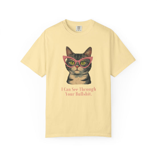 A pale yellow short-sleeve t-shirt with a graphic of a tabby cat wearing pink glasses and the text 'I Can See Through Your Bullshit.' printed below, displayed on a clean white background.