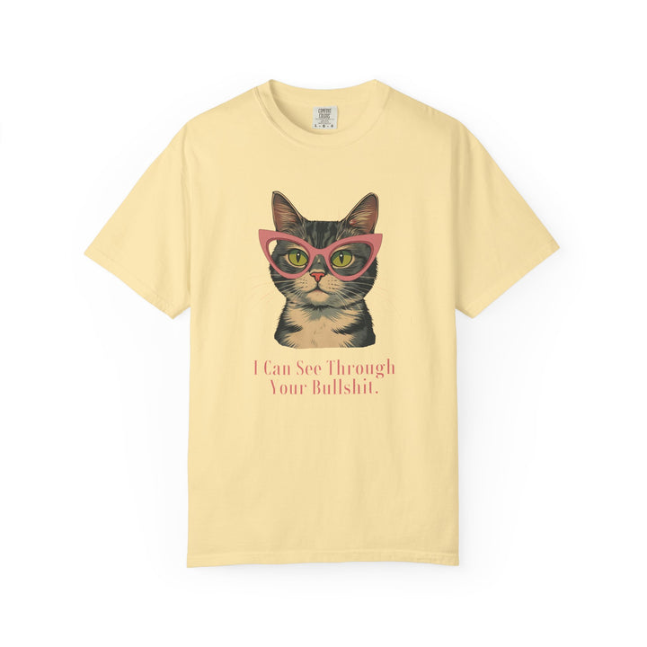 A pale yellow short-sleeve t-shirt with a graphic of a tabby cat wearing pink glasses and the text 'I Can See Through Your Bullshit.' printed below, displayed on a clean white background.