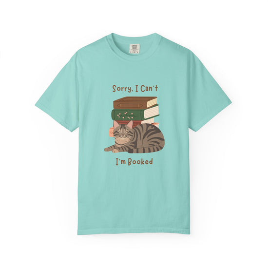 Blue  cotton tshirt with graphic of a cat laying in front of stack of books.  Text says, Sorry, I can't.  I'm booked.