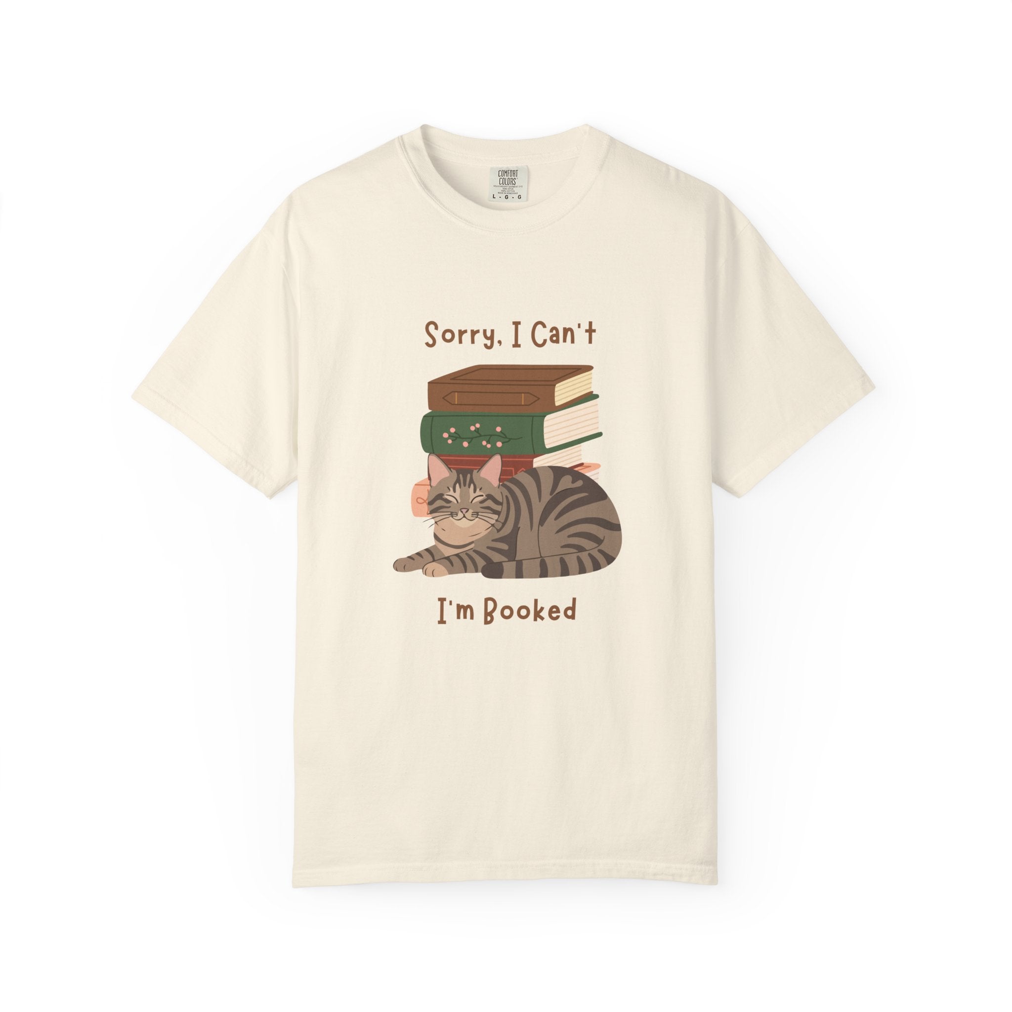 White cotton tshirt with graphic of a cat laying in front of stack of books.  Text says, Sorry, I can't.  I'm booked.