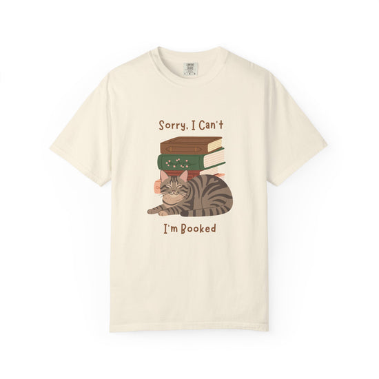 White cotton tshirt with graphic of a cat laying in front of stack of books.  Text says, Sorry, I can't.  I'm booked.