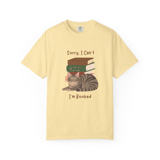 Yellow cotton tshirt with graphic of a cat laying in front of stack of books.  Text says, Sorry, I can't.  I'm booked.