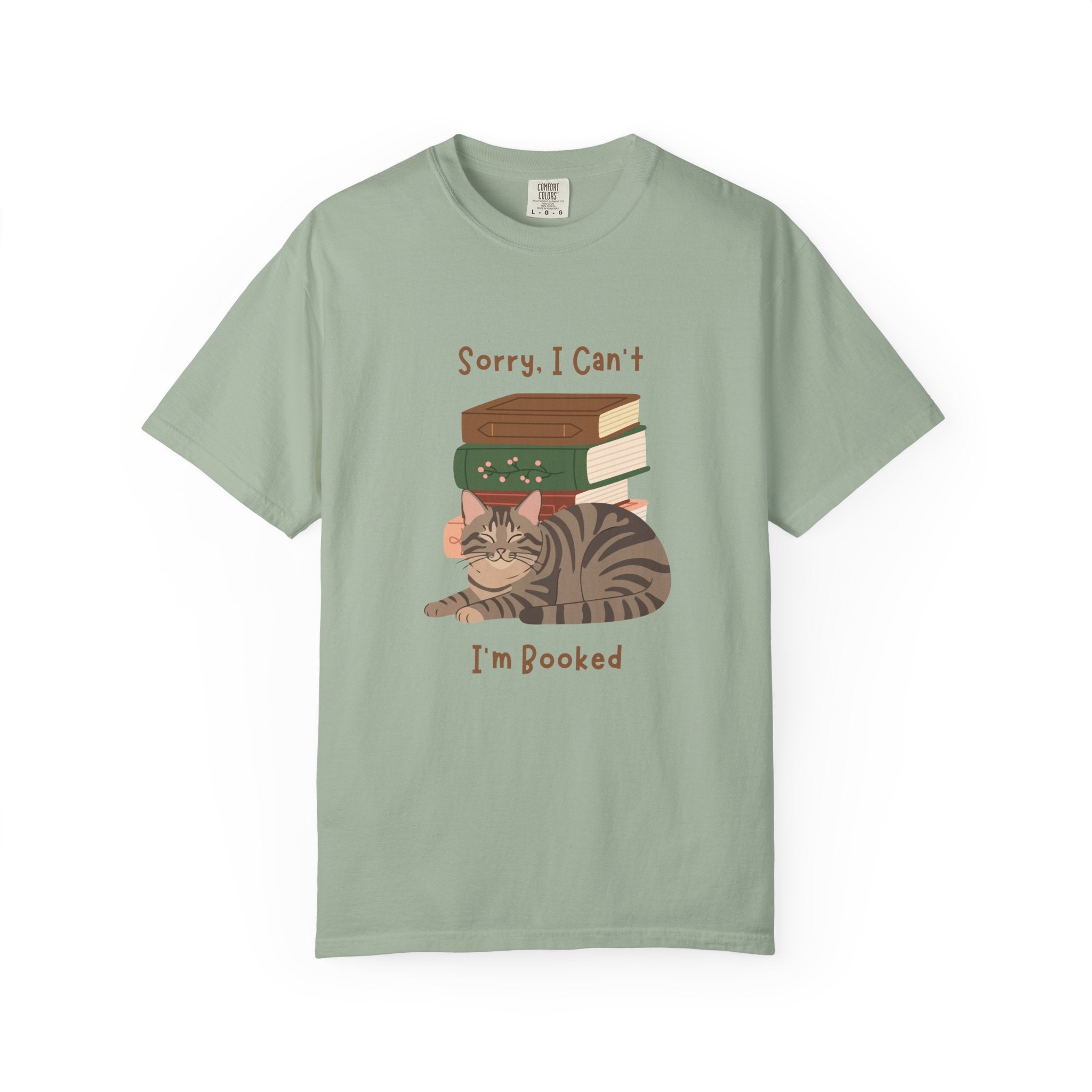 Green cotton tshirt with graphic of a cat laying in front of stack of books.  Text says, Sorry, I can't.  I'm booked.