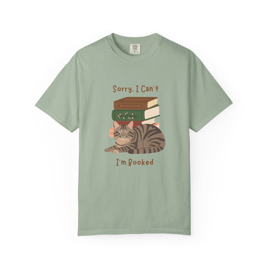 Green cotton tshirt with graphic of a cat laying in front of stack of books.  Text says, Sorry, I can't.  I'm booked.