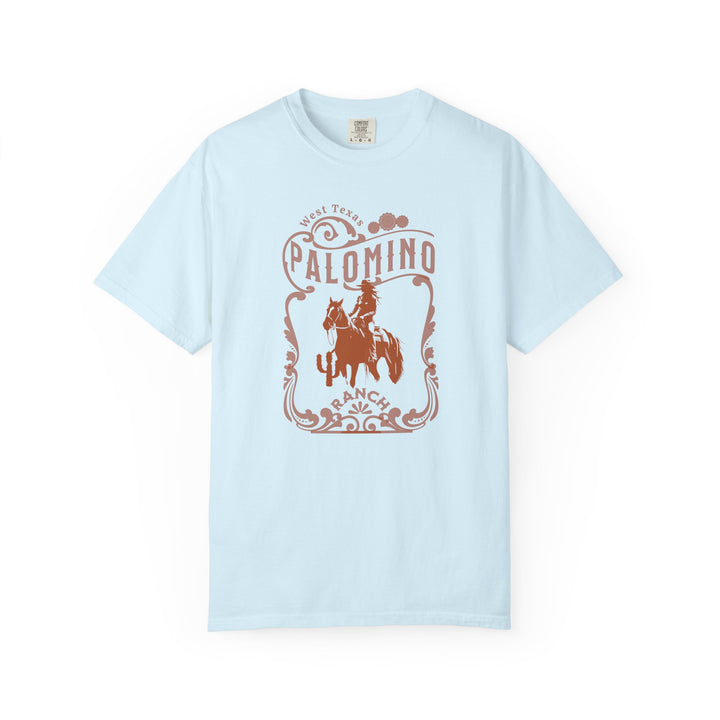 Light blue t-shirt with a graphic design of a horse and rider, and 'Palomino Ranch' text 