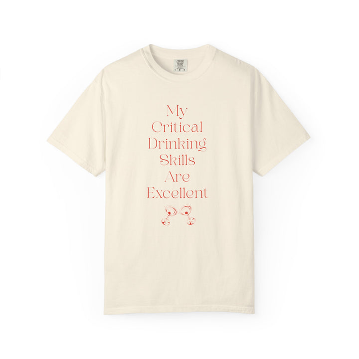 Ivory short sleeve, crew neck t-shirt has text that says "My critical drinking skills are excellent" and  a graphic of two martini glasses.