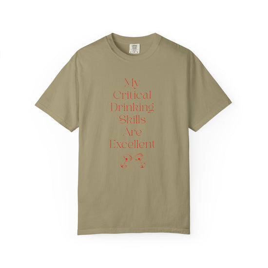 Khaki short sleeve, crew neck t-shirt has text that says "My critical drinking skills are excellent" and  a graphic of two martini glasses.