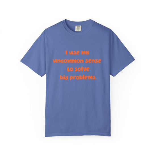 Blue short sleeve, crew neck t-shirt has orange type that says "I use my uncommon sense to solve big problems."
