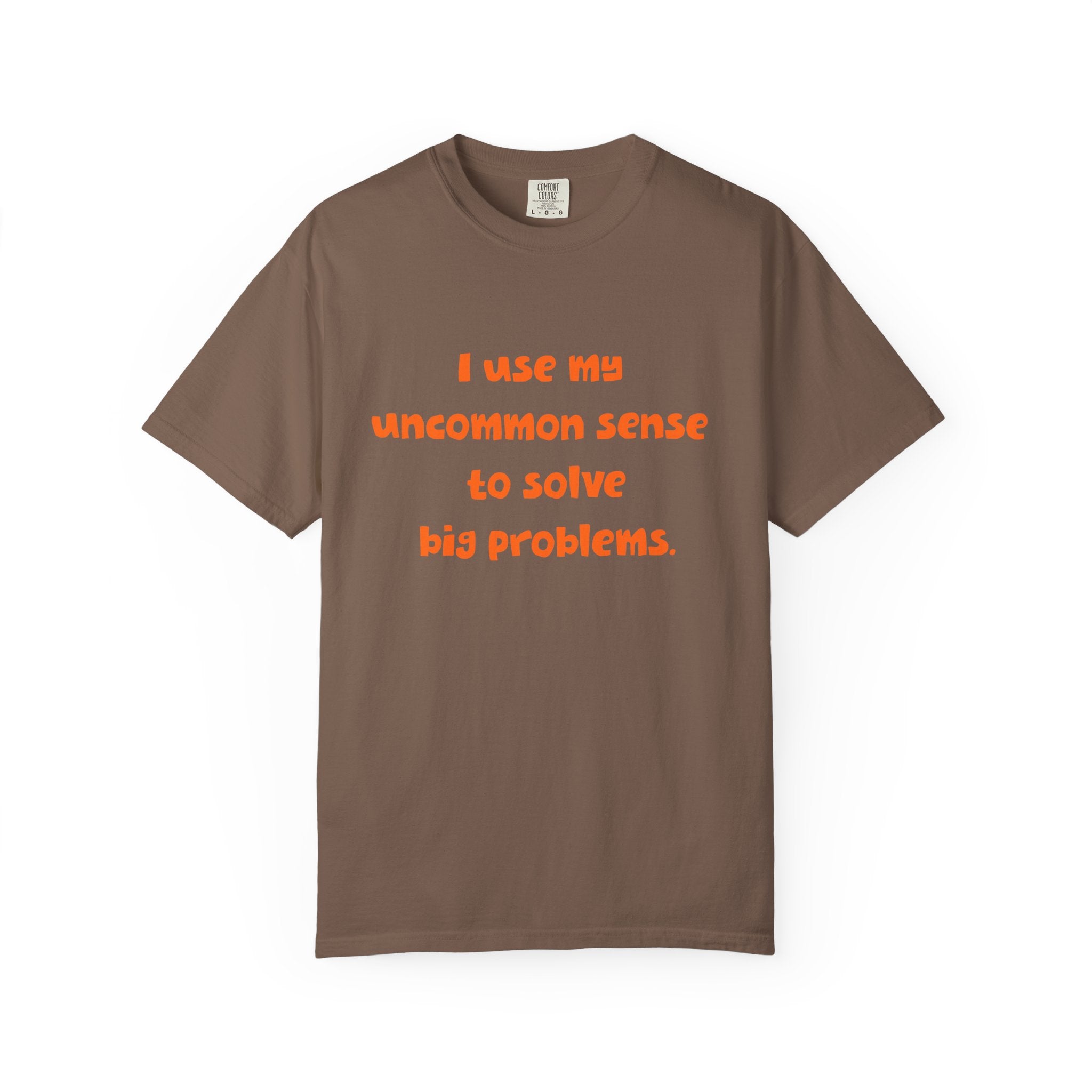 Brown short sleeve, crew neck t-shirt has orange type that says "I use my uncommon sense to solve big problems."