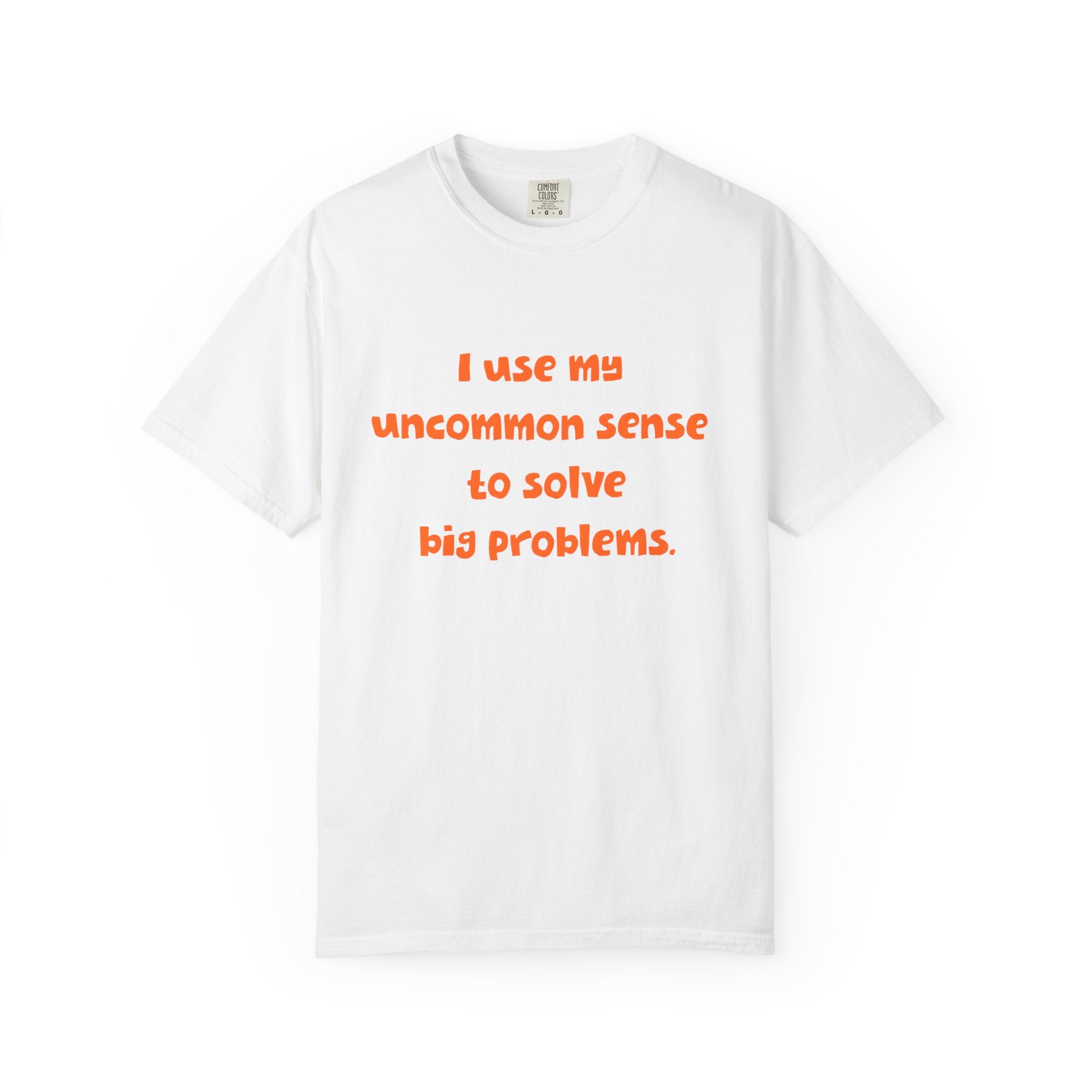 White short sleeve, crew neck t-shirt has orange type that says "I use my uncommon sense to solve big problems."