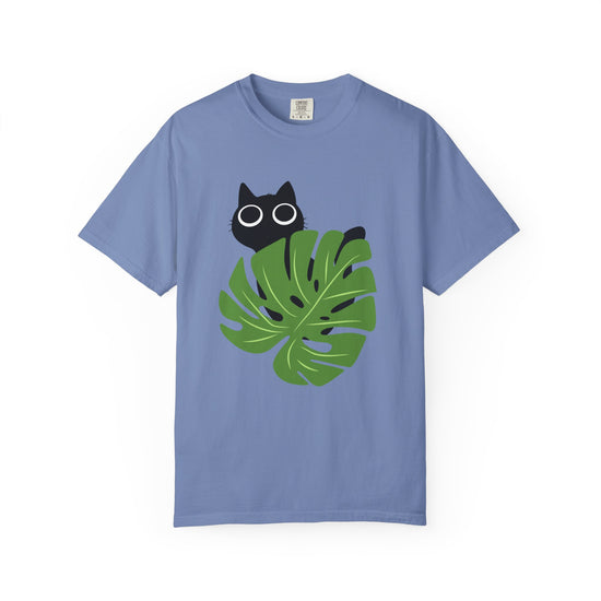 Blue  short-sleeve crewneck t-shirt featuring a graphic of a black cat peeking over a green monstera leaf with white-rimmed glasses, displayed on a clean white background.