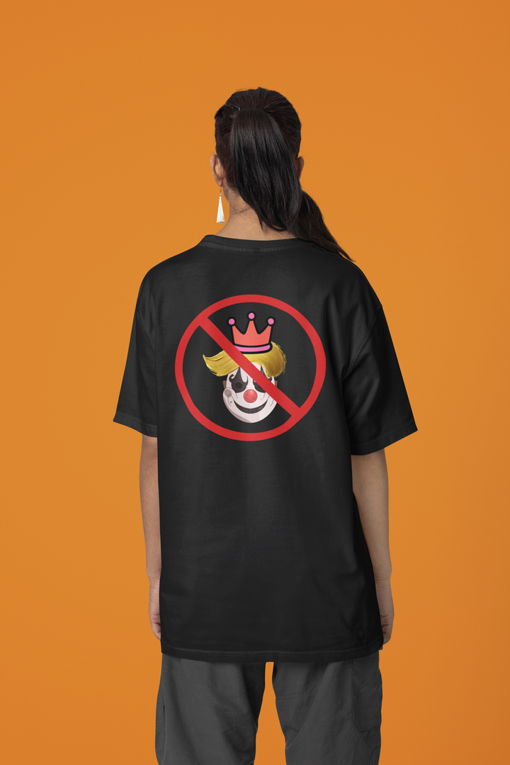 A person shown from the back wearing a black oversized T-shirt with a red prohibition symbol over a clown graphic on the back, photographed against a solid orange studio background.