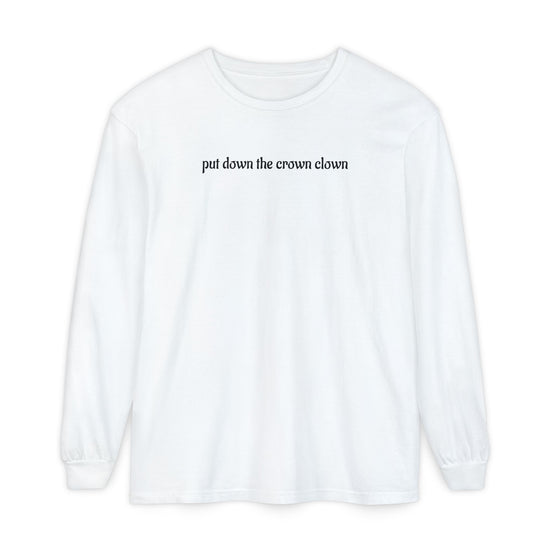 A white long-sleeve t-shirt with the phrase 'put down the crown clown' printed in black serif font across the chest, displayed on a clean white background.