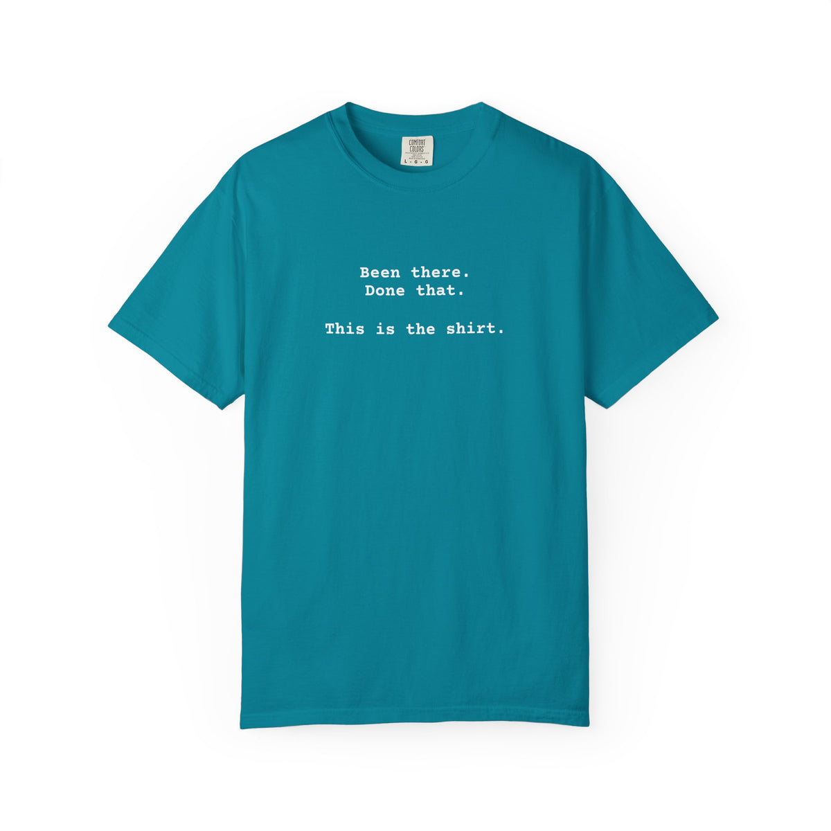 Blue t-shirt with text on a white background says "Been There.  Done That.  Here's The T-shirt" in a simple typewriter font.