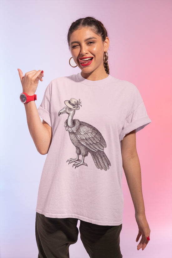 Pink t-shirt with a graphic of a vulture bird wearing a vintage hat on woman