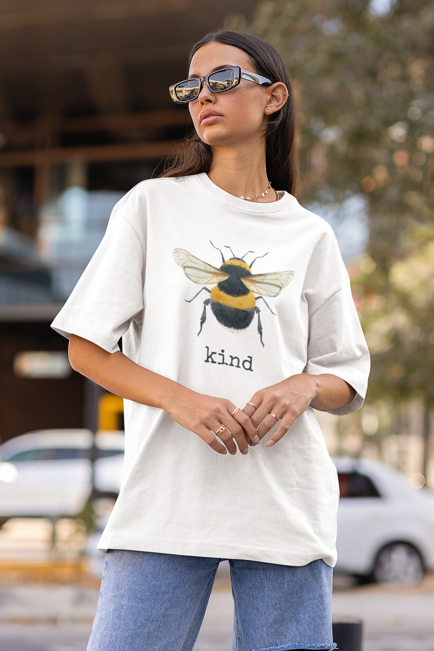 White organic cotton short sleeve, crew neck t-shirt has graphic of a bumble bee and text that says "kind"