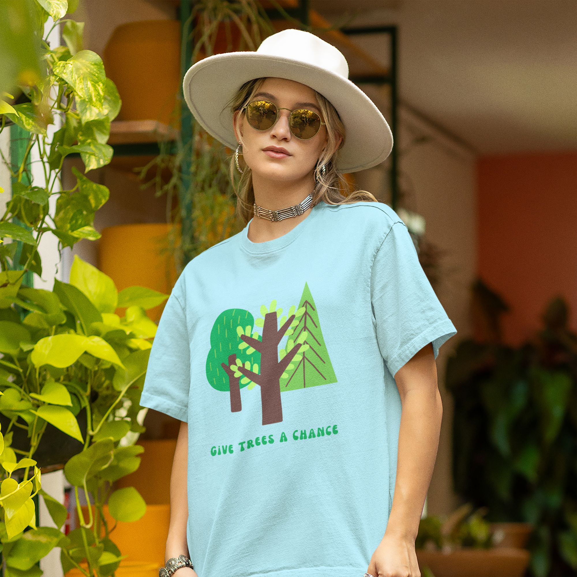 Blue -shirt with green tree graphic and text says "GIve Trees A Chance." worn by woman